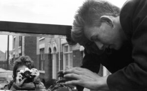 Photographer Russell Boyce is reflected in a mirror as Rag and Bone man George Norris adjusts the load on his horse and cart in Hull 1983. Picture by Russell Boyce